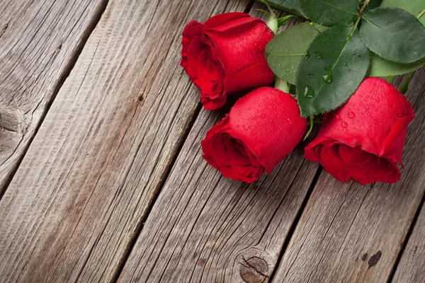 Rosas rojas sobre madera — Foto de Stock