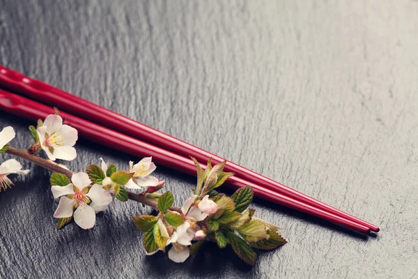 Palillos de sushi japoneses y flor de sakura — Foto de Stock