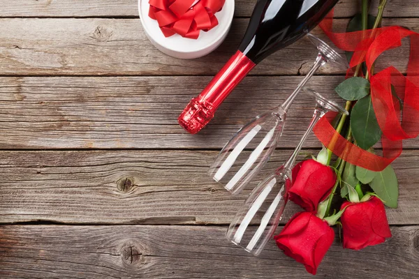 Rote Rosen mit Geschenk und Champagner — Stockfoto