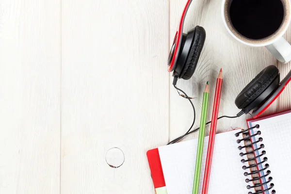 Escritorio con bloc de notas, café y auriculares — Foto de Stock