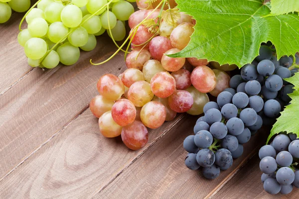 Ramo de uvas sobre fondo de madera — Foto de Stock