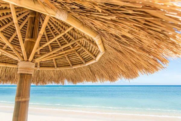 Straw umbrella on  tropical beach — Stock Photo, Image