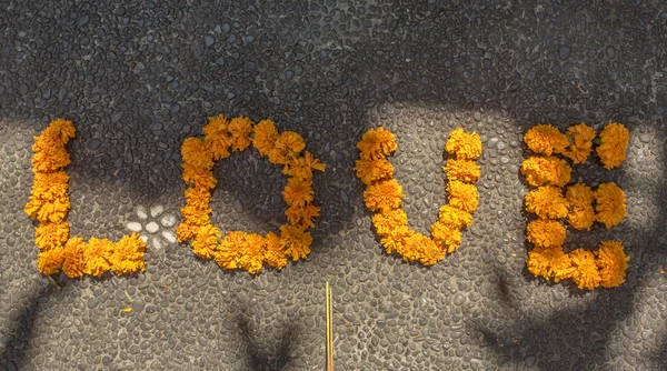 Love sign made with marigold flowers — Stock Photo, Image