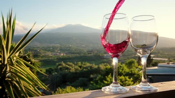 Verter vino tinto de una botella en dos copas en los viñedos de Sicilia — Vídeos de Stock