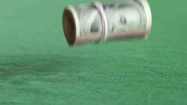 Vallende rol van honderd Amerikaanse dollar biljetten met witte elastiekjes — Stockvideo