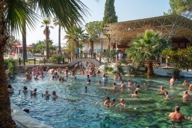 Türkiye 'nin Pamukkale kentindeki Antik havuzda veya Kleopatras Hamamında kimliği belirsiz turistler banyo yapıyor