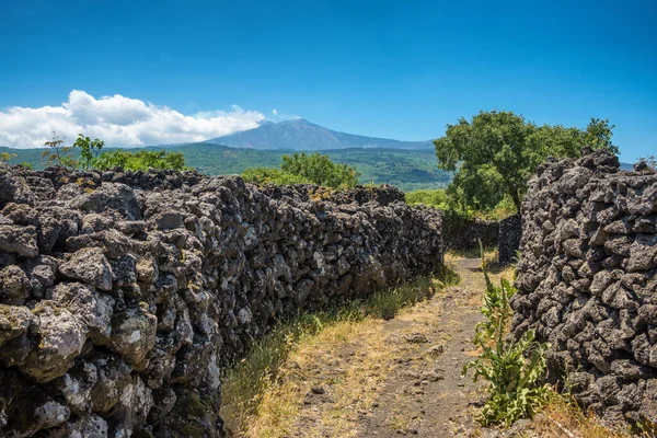 Route rurale le long du vieux mur de pierre de lave avec vue sur le volcan Etna en Sicile — Photo