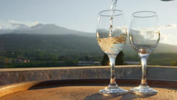 Nalévání červeného vína z láhve do dvou sklenic na vinicích na Sicílii