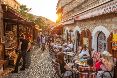 BH 'nin eski Mostar kentinde kafeler ve hediyelik eşya dükkanlarıyla döşenmiş cadde