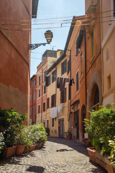 Jalanan sempit yang nyaman dengan cucian kering di distrik Trastevere, Roma, Italia — Stok Foto