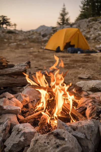 Oheň hoří v turistickém táboře v horách. — Stock fotografie
