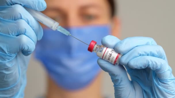 Женщина-врач держит пузырек с вакциной от шприца и коронавируса. — стоковое видео