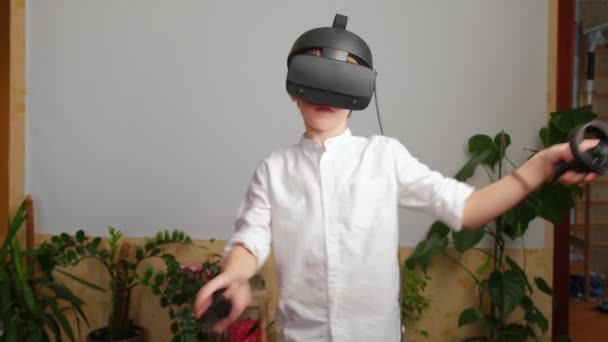 Joven juego de niños con un casco de realidad virtual VR en casa. — Vídeo de stock