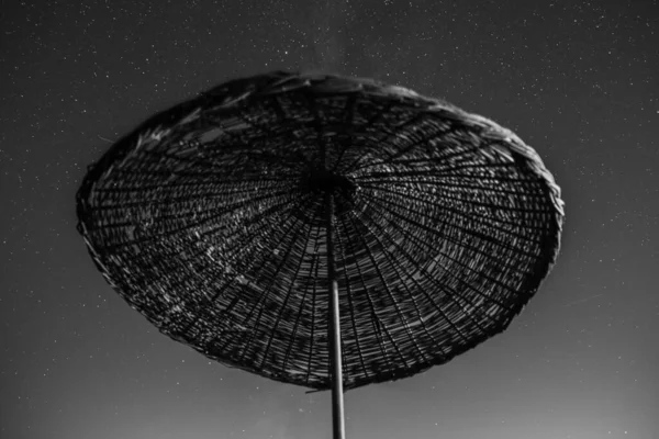 Ομπρέλα παραλίας με νυχτερινό ουρανό γεμάτο αστέρια. — Φωτογραφία Αρχείου