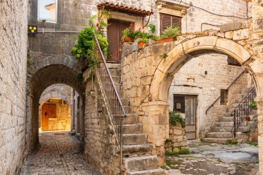 Trogir şehrinde çiçek saksıları ve temiz çamaşırları olan resim gibi bir cadde.