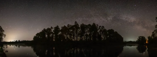 Silhuetas de árvores à beira do rio à noite — Fotografia de Stock