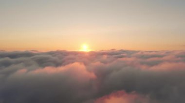 Beyaz yoğun bulutların üzerinde gün doğumunun havadan görünüşü