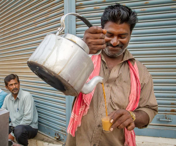 L'uomo versa tazza di tè caldo al latte — Foto Stock