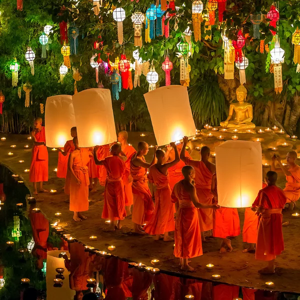 Buddhist monks lighting candles to the Buddha statue — Stock Photo, Image