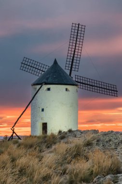 Günbatımında Consuegra 'nın tarihi yel değirmenleri, Castilla-La Mancha, İspanya. Akşam ışığında tepelerde Don Kişot 'un eski tarihi yel değirmenleri. Molinos de Viento de Consuegra