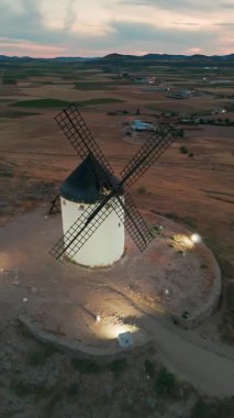 Consuegra 'nın tarihi yel değirmenlerinin geceleri havadan görünüşü, Castilla-La Mancha, İspanya. Alacakaranlıktaki tepelerde Don Kişot karakterinin eski tarihi yel değirmenleri. Molinos de Viento de Consuegra