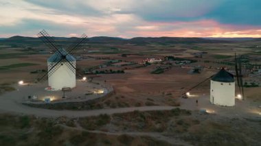 Consuegra 'nın tarihi yel değirmenlerinin geceleri havadan görünüşü, Castilla-La Mancha, İspanya. Alacakaranlıktaki tepelerde Don Kişot karakterinin eski tarihi yel değirmenleri. Molinos de Viento de Consuegra