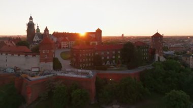 Polonya 'nın eski tarihi Krakow şehrindeki muhteşem Wawel Kalesi' nin üzerinde güzel bir gün doğumu. Wawel Hill 'deki kraliyet konutunun havadan görünüşü, sabah ışığında parlıyor.