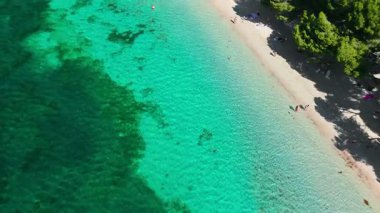 Playa de Formentor 'un Mallorca' daki Cala Pi de la Posada körfezindeki hava manzarası. Cap Formentor, Mayorka, Balear Adaları, İspanya 'da turkuaz sularda yüzen insanların olduğu çarpıcı bir sahil..