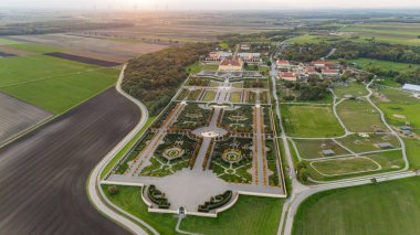 Avusturya, Marchfeld 'de gün batımında Schloss Hof Kalesi' nin hava manzarası. Görkemli Barok Sarayı güzel manzaralı resmi bahçelerle çevrili, klasik Avrupa mimarisinin güzel bir örneği..