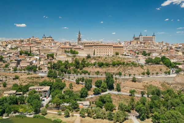 Исторический городской пейзаж Толедо, Кастилия-Ла-Манча, Испания. Красивый средневековый город с Альказаром Толедо, собором Санта-Мария и другими историческими зданиями, объектом Всемирного наследия ЮНЕСКО.