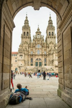 Santiago de Compostela, İspanya - 10 Temmuz 2024: Santiago de Compostela Katedrali 'nin eteklerinde dinlenen hacılar. Ünlü Hristiyan kutsal mekanı ve Camino de Santiago yolunun bitiş noktası..