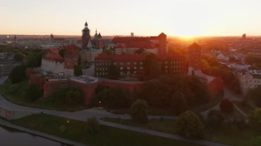 Polonya 'nın eski tarihi Krakow şehrindeki muhteşem Wawel Kalesi' nin üzerinde güzel bir gün doğumu. Wawel Hill 'deki kraliyet konutunun havadan görünüşü, sabah ışığında parlıyor.