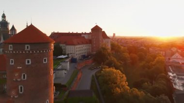Polonya 'nın eski tarihi Krakow şehrindeki muhteşem Wawel Kalesi' nin üzerinde güzel bir gün doğumu. Wawel Hill 'deki kraliyet konutunun havadan görünüşü, sabah ışığında parlıyor.