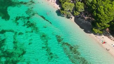 Playa de Formentor 'un Mallorca' daki Cala Pi de la Posada körfezindeki hava manzarası. Cap Formentor, Mayorka, Balear Adaları, İspanya 'da turkuaz sularda yüzen insanların olduğu çarpıcı bir sahil..