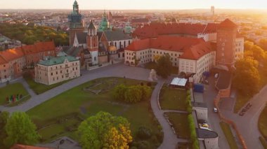 Polonya 'nın eski tarihi Krakow şehrindeki muhteşem Wawel Kalesi' nin üzerinde güzel bir gün doğumu. Wawel Hill 'deki kraliyet konutunun havadan görünüşü, sabah ışığında parlıyor.