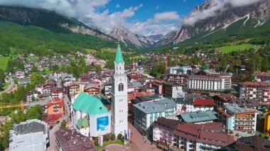 İtalya 'nın Cortina dAmpezzo kentinin erimene bakan manzarasında, Dolomites dağları, Veneto bölgesi, Belluno ilinin küçük bir kasabası olan Basilica dei Santi Filippo e Giacomo yer alıyor..
