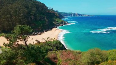 Gijon, Asturias yakınlarındaki inanılmaz Playa de La Nora plajı, kuzey İspanya. Asturias 'ın Cantabrian Denizi kıyısı boyunca turkuaz deniz suyuyla cennet gibi beyaz kumsal manzarası..