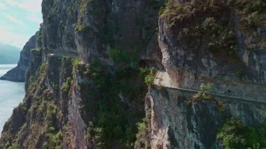 İtalyan Alpleri 'nde Garda Trentino' daki hayali Ponale Yolu 'nun havadan görünüşü, bu ikonik dağ yolunda yürüyen yürüyüşçü ve bisikletçilerle Garda Gölü' nün yukarısında sarsılıyor..