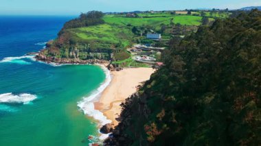 Gijon, Asturias yakınlarındaki inanılmaz Playa de La Nora plajı, kuzey İspanya. Asturias 'ın Cantabrian Denizi kıyısı boyunca turkuaz deniz suyuyla cennet gibi beyaz kumsal manzarası..