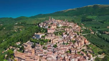 İtalya 'nın Umbria kentindeki Trevi kentinde bulunan ve tarihi taş mimarisi, teraslı manzara ve panoramik kırsal manzaralı ortaçağ dağ köyünün havadan görünüşü.