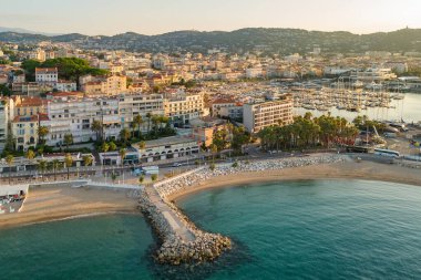 Gündoğumunda Cannes 'da lüks oteller ve konut binaları olan güzel plajın havadan görüntüsü. Yaz boyunca muhteşem Cote dAzur kıyıları