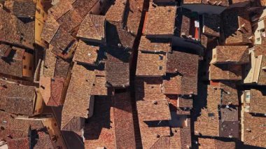 Anversa degli Abruzzi 'deki geleneksel turuncu kiremitli çatıların ve antik taş evlerin yukarıdan görünüşü. Güneşli bir günde bu Abruzzo köyünün ortaçağ mimarisi ve dar sokakları vurgulanıyor..