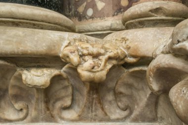 İtalya 'nın Cenova kentindeki San Lorenzo Katedrali' nin Gotik cephesine oyulmuş küçük, efsanevi taş köpek heykelinin detaylı bir görüntüsü.