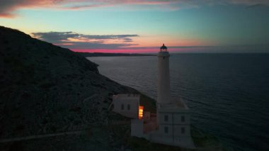 Alacakaranlıktaki tarihi Punta Palascia deniz fenerinin hava manzarası. İtalya 'nın en doğusundaki Salento bölgesi Puglia' da, Adriyatik Denizi üzerinde dönen ışık huzmeleri.