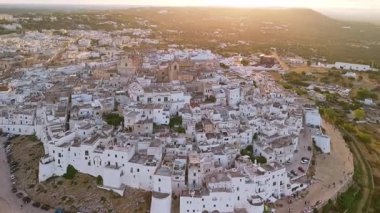 Gün batımında Ostuni 'nin hava manzarası. Tepe Beyaz Şehir, altın saat ışığında parıldıyor. Puglia İtalya 'daki zeytinliklere ve Adriyatik Denizi' ne bakıyor..