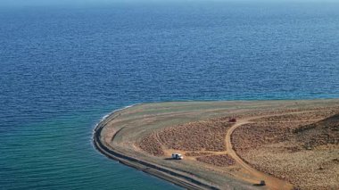 Semendirek, Yunanistan. Doğu kıyısındaki dolambaçlı sahil yolunun hava manzarası uzak Kipos plajına, dramatik yüksek uçurumlara ve mavi Ege Denizi 'ne çıkıyor..