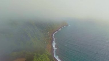 Portekiz, Azores 'te bulutlu ve sisli havada Miradouro da Ponta do Sossego' dan görülen Sao Miguel adasının yüksek yeşil uçurumları. Dramatik Atlantik adası doğası olan manzaralı kıyı manzarası..