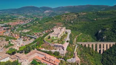 İtalya 'da güneşli bir yaz gününde Duomo di Santa Maria Assunta, Ponte delle Torri su kemeri ve Rocca Albornoziana kalesinin hava manzarası.