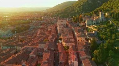 Gün batımında Gubbio, İtalya 'nın nefes kesici hava manzarası. Ortaçağ binaları, Duomo ve Umbria bölgesinde sıcak bir akşam gökyüzü altında parlayan Gotik mimarisi ile dar sokaklar sergileniyor..