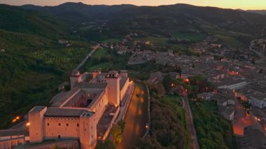 Ortaçağ Spoleto 'sunun dramatik hava manzarası, Umbria' nın geceleri. İtalya 'da şehir ışıkları altında parıldayan Ponte delle Torri su kemeri ve Rocca Albornoziana kalesi yer alıyor..